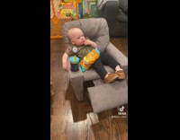 Baby eats chips on small recliner chair 