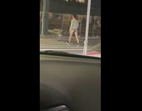 Guy walking on sidewalk at night in underwear and sweater