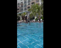 Woman in bikini kneels down on the pool