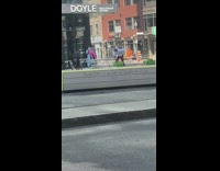 Woman in blue winter coat and pink scarf poses in front of the building