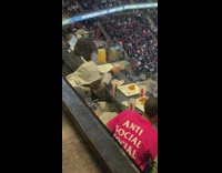 Man poses with his food on the game stadium