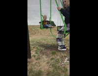 Mother swinging on a couple swing with toddler