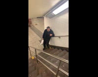 Black bandana guy smokes subway station stairs