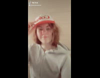 Girl takes grey jacket red hat off