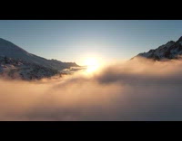 Drone shot ascend from clouds show mountain sunrise