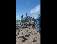 Man in neon green handstands on the rocks