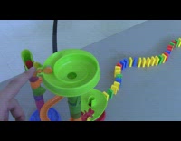 Rube Goldberg machine on table ball hits dominos