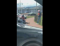Two guys pose front parked cars