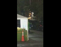 Green alien costume guy rides skateboard street 