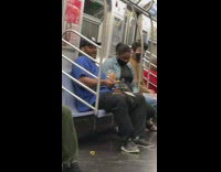 Man feeds chip to pigeon in his lap on the train