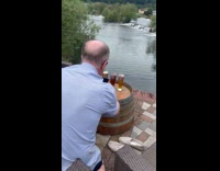 Man takes picture of beer near river