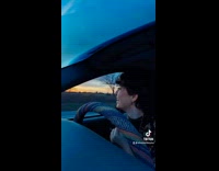 Girl stops driving to spin around sunset 
