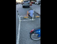 Guy sits in front of a small fire on street 