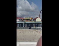 Woman in black beach dress poses on the beach