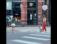 Woman orange pants dog middle pedestrian lane