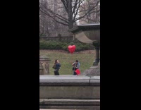 Photographer heart balloon takes picture of woman