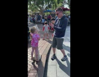 Little girl poses beside a small horse head statue