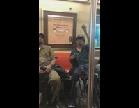 Woman New York hat sews long wig weave on subway train while listening to music