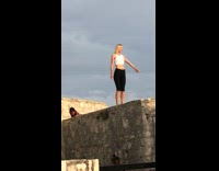 Blonde woman yoga shorts stand stone ledge
