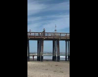 Woman photo shoot boundary gate pier beach