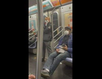 Guy riding subway train with a scream mask