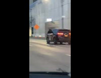 Guy on bicycle holding onto car at high speed