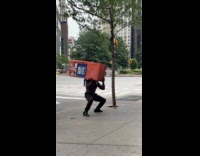 Shirtless man doing squats uses barrier as weights