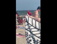 Spiderman taking picture with people at beach