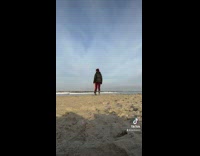 Stranger stands in front of camera on beach
