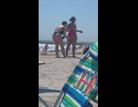 Two women fixes bikini flex butt beach