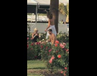 Man shirtless towel selfie tree flower bushes