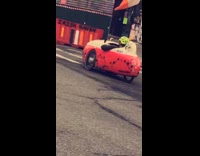 Guy rides small three wheeled red car