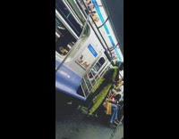 Guy in yellow scarf and high heels plays saxophone on subway train