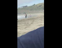 Three men walk beach video shoot