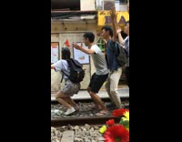 Tourists pose for photo on train tracks 