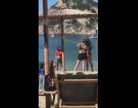 Red shirt girl poses beach straw umbrella 
