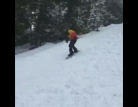 Snowboarder red yellow jacket backflips downhill and fails