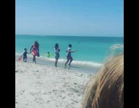 Guy jumps claps feet for beach picture