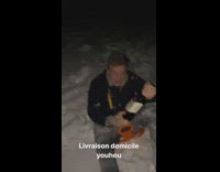 Guy rides orange sled down snow hill 