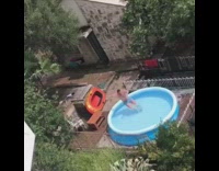 Guy records friend jumping into blue blow up pool in backyard home breaks pool water spills