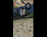 Prius fell off cliff upside down on sand beach