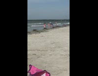 Women in pink bikini kneels at the beach Part 1