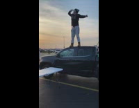 man jumps black truck folding table