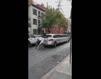 Limousine car push by men along the street in NYC 