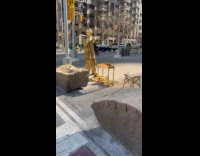 Gold mime man sprays paint on hands