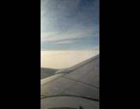 Airplane window view on top of the clouds