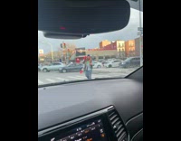 Guy juggles red pins while walking through crosswalk 