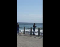 Two girls black shirt beach pier phone 