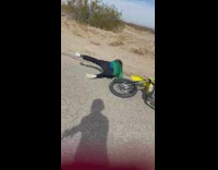 Guy doing wheelie on dirt bike flips over