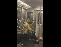 Man yellow hat jacket sits on subway train with iguana on his head